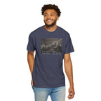 Smiling man wearing a Denim Comfort Colors t-shirt with a printed design of Trumbull's  'Declaration of Independence' painting with '1776-2026' in overlapping revolutionary era text