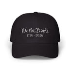 Black cap with embroidered 'We the People 1776-2026' against a white background