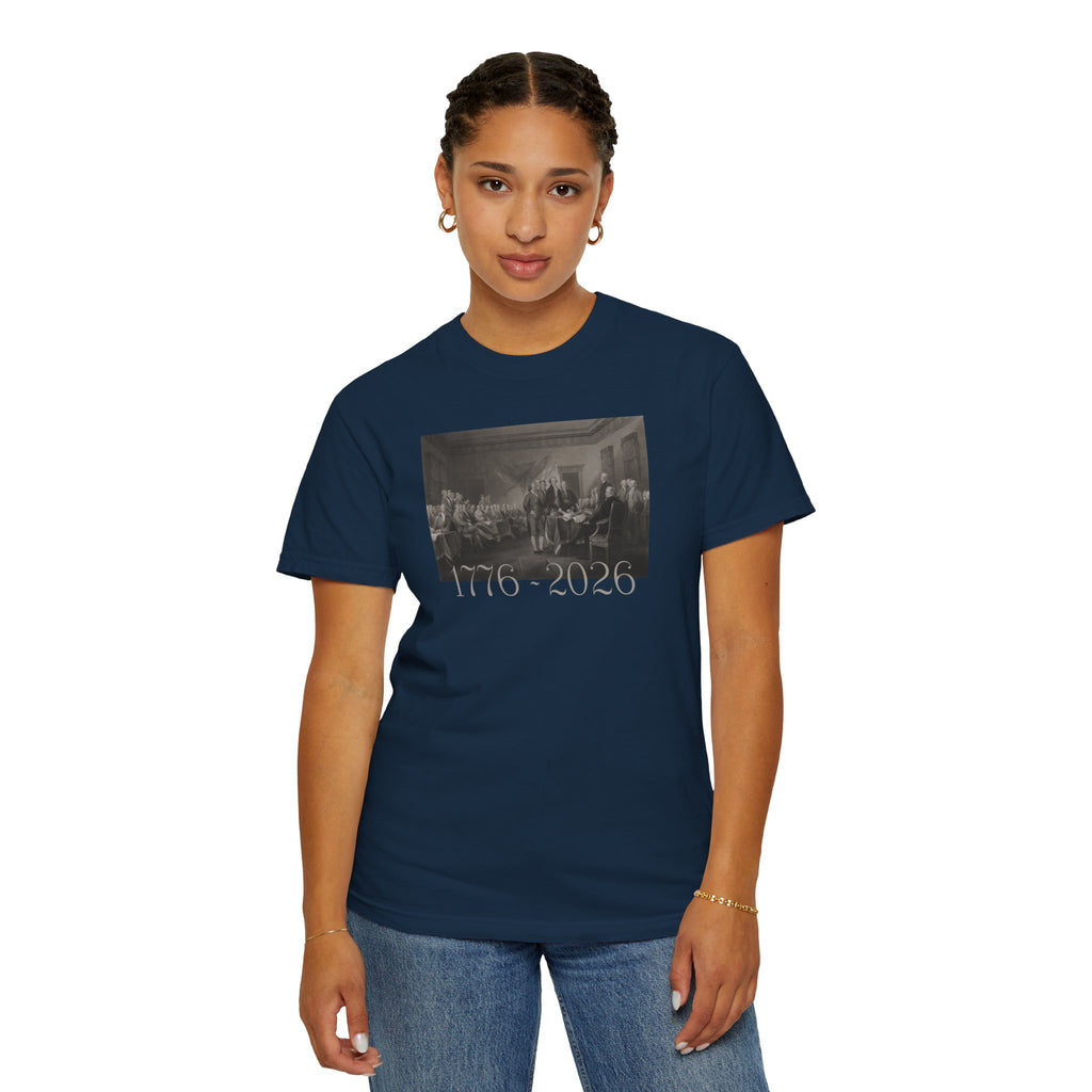 Woman wearing a True Navy Comfort Colors t-shirt with a printed design of Trumbull's  'Declaration of Independence' painting with '1776-2026' in overlapping revolutionary era text