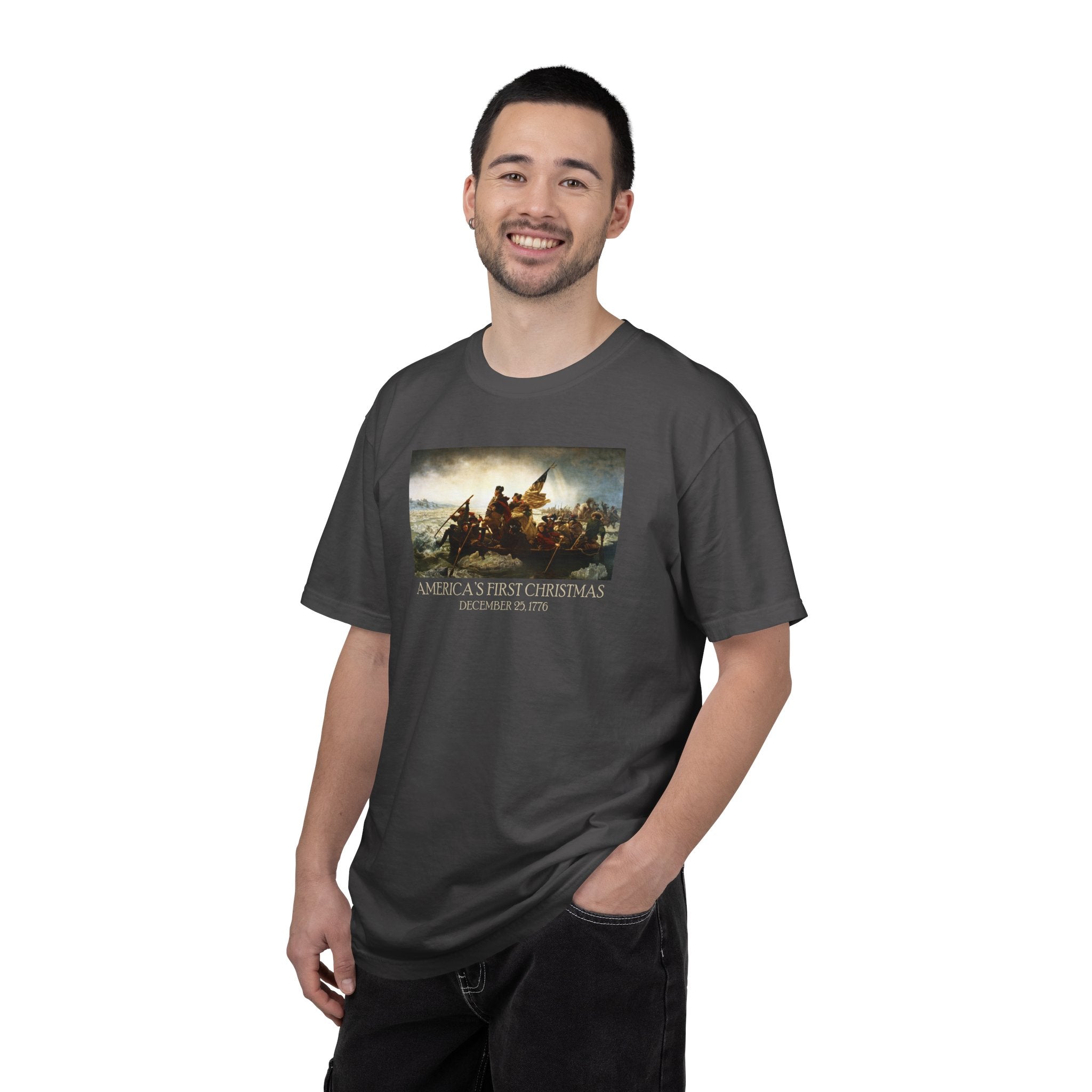 Smiling man wearing a Graphite Comfort Colors t-shirt with print of Emanuel Leutze’s 'Washington Crossing the Delaware' with 'America's First Christmas December 25, 1776' printed below 