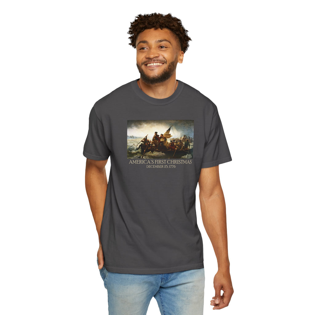 Smiling Man wearing a Graphite Comfort Colors t-shirt with print of Emanuel Leutze’s 'Washington Crossing the Delaware' with 'America's First Christmas December 25, 1776' printed below 