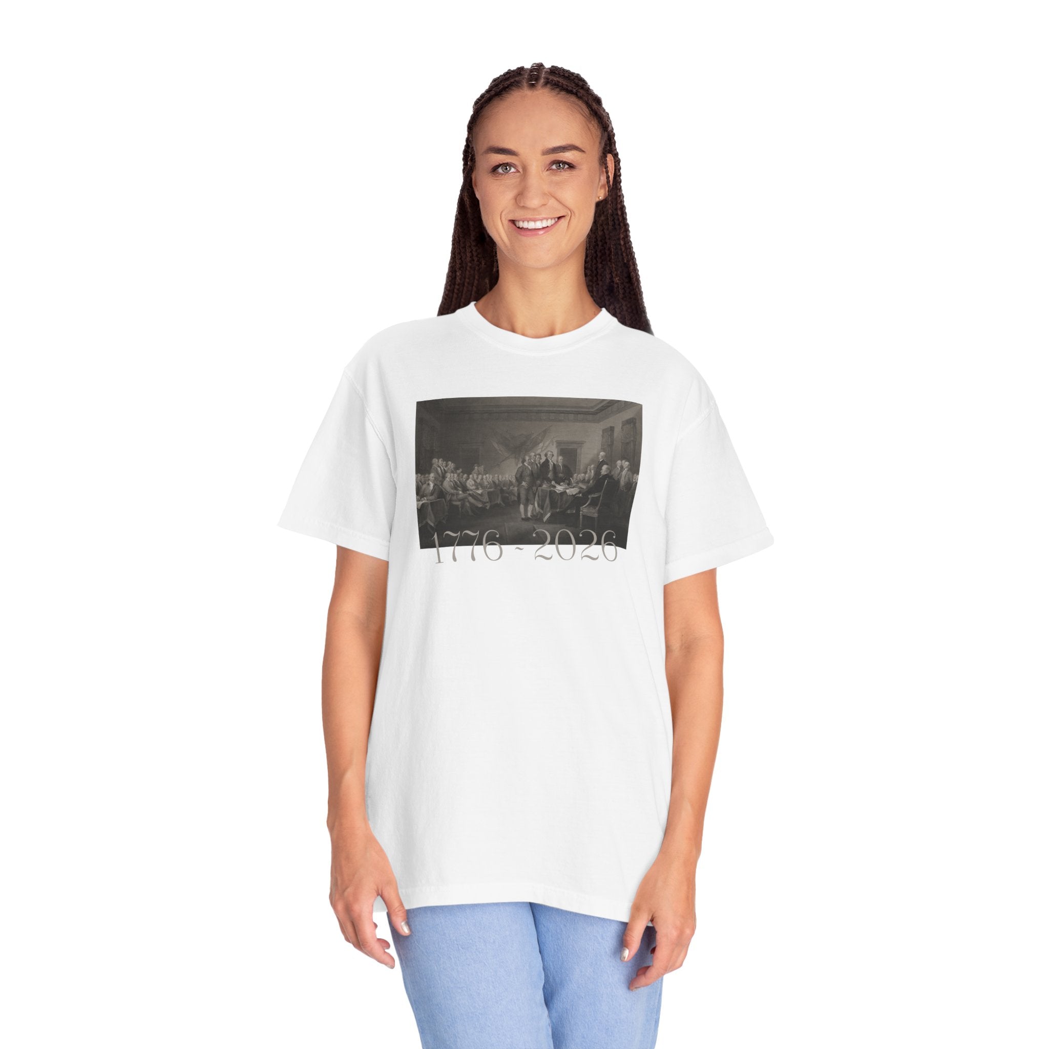 Woman wearing an oversized White Comfort Colors t-shirt with a printed design of Trumbull's  'Declaration of Independence' painting with '1776-2026' in overlapping revolutionary era text