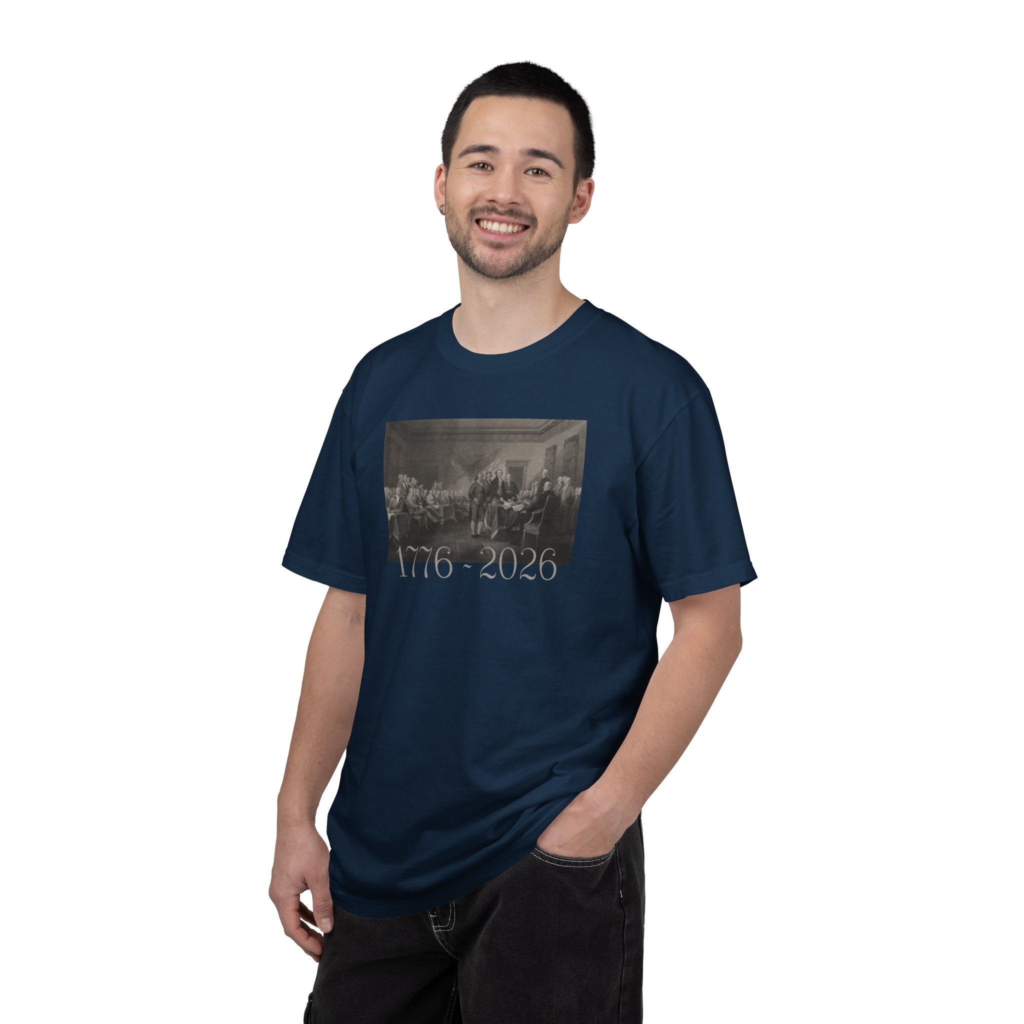 Man wearing a True Navy Comfort Colors t-shirt with a printed design of Trumbull's  'Declaration of Independence' painting with '1776-2026' in overlapping revolutionary era text