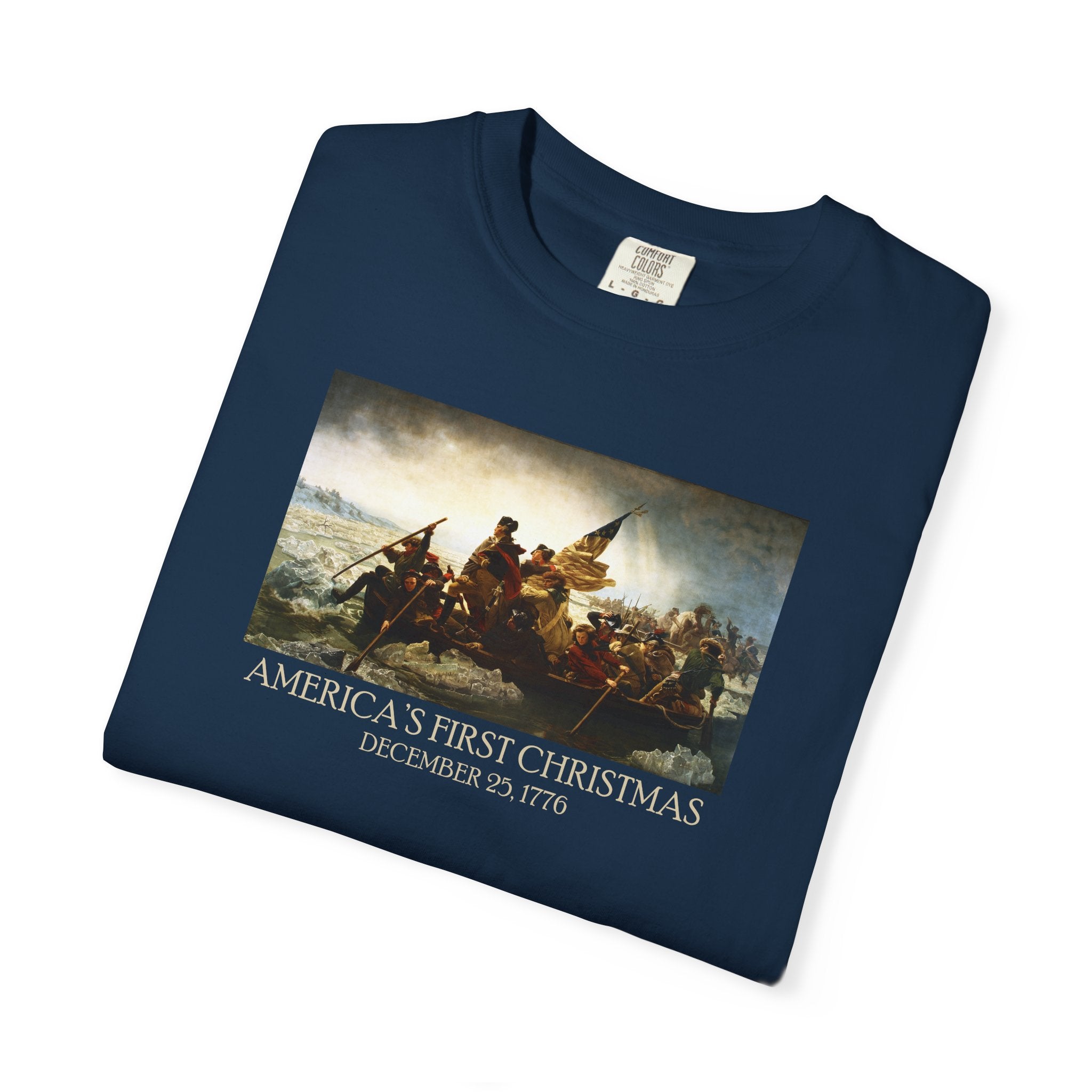 Folded True Navy Comfort Colors t-shirt with print of Emanuel Leutze’s 'Washington Crossing the Delaware' with 'America's First Christmas December 25, 1776' printed below 