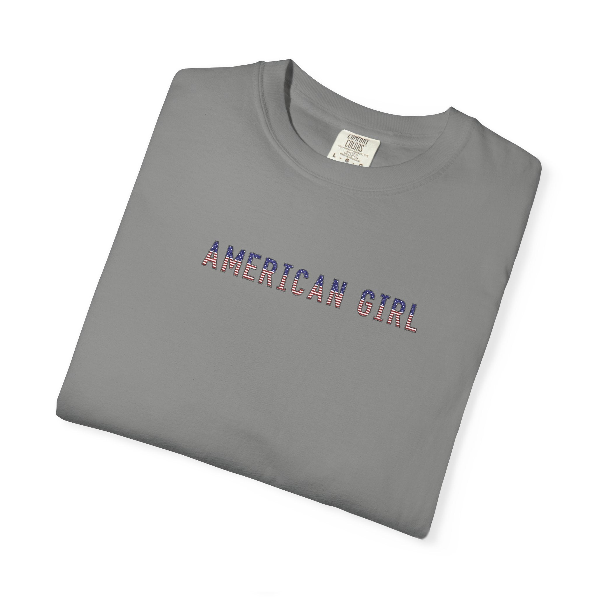 Folded granite colored t-shirt with 'American Girl' in patriotic stars & stripes text