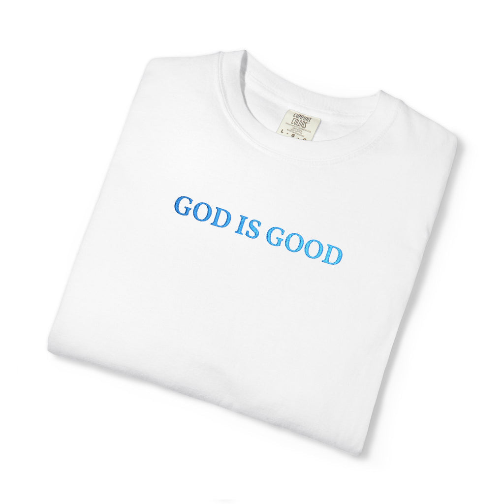 Folded White t-shirt embroidered with 'GOD IS GOOD' in cornflower blue thread