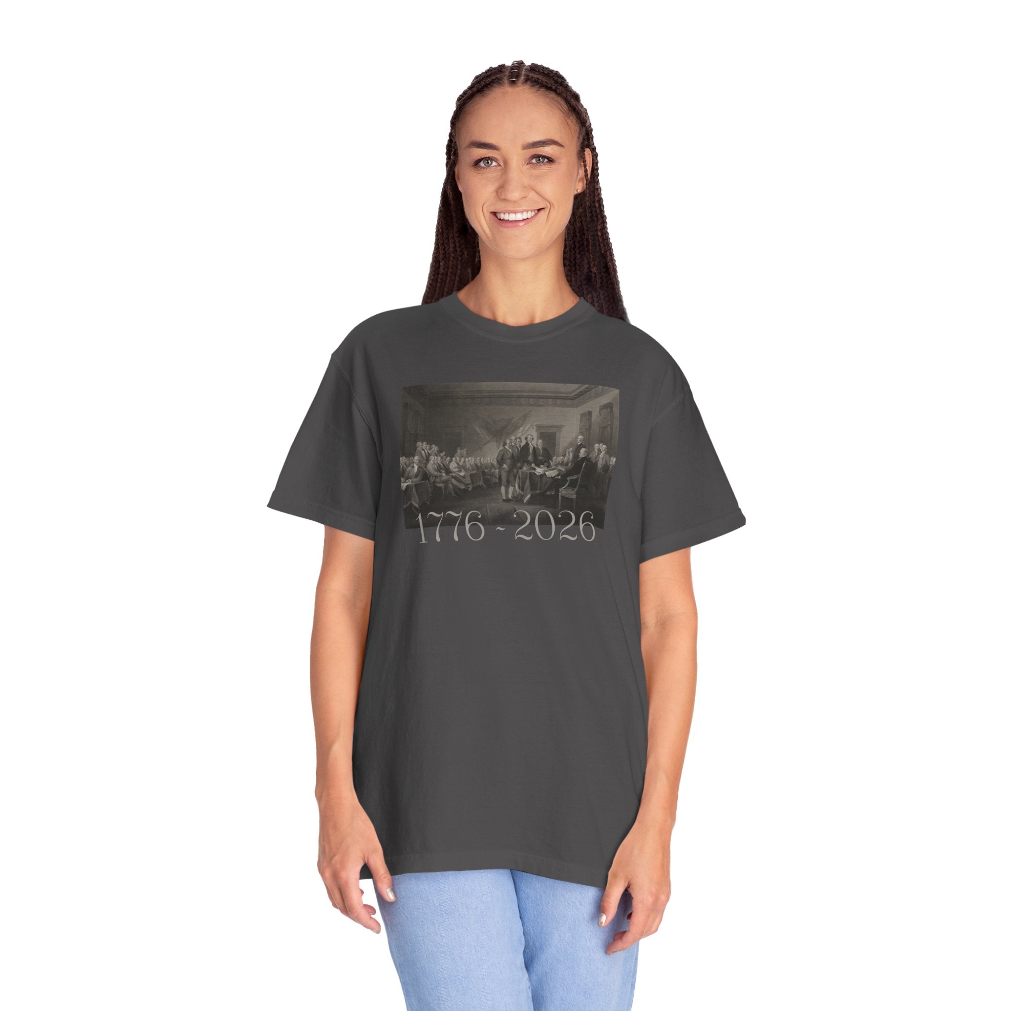 Woman wearing an oversized Graphite Comfort Colors t-shirt with a printed design of Trumbull's  'Declaration of Independence' painting with '1776-2026' in overlapping revolutionary era text