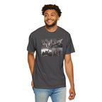 Smiling man wearing a Graphite Comfort Colors t-shirt printed with a montage of four revolutionary war era paintings