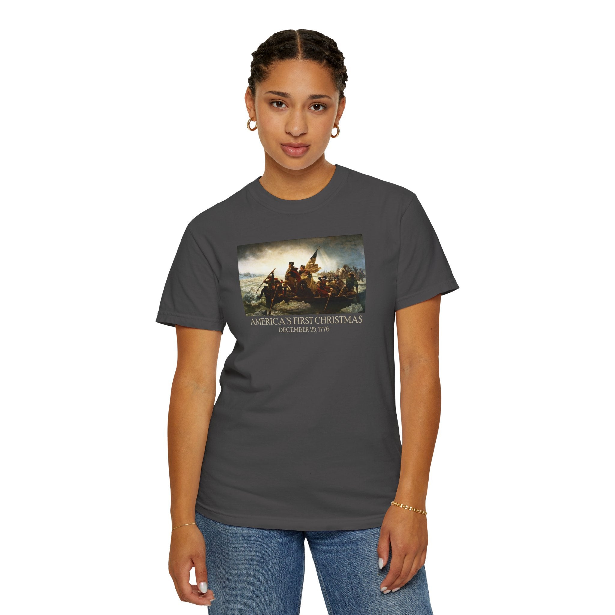 Woman wearing a Graphite Comfort Colors t-shirt with print of Emanuel Leutze’s 'Washington Crossing the Delaware' with 'America's First Christmas December 25, 1776' printed below 