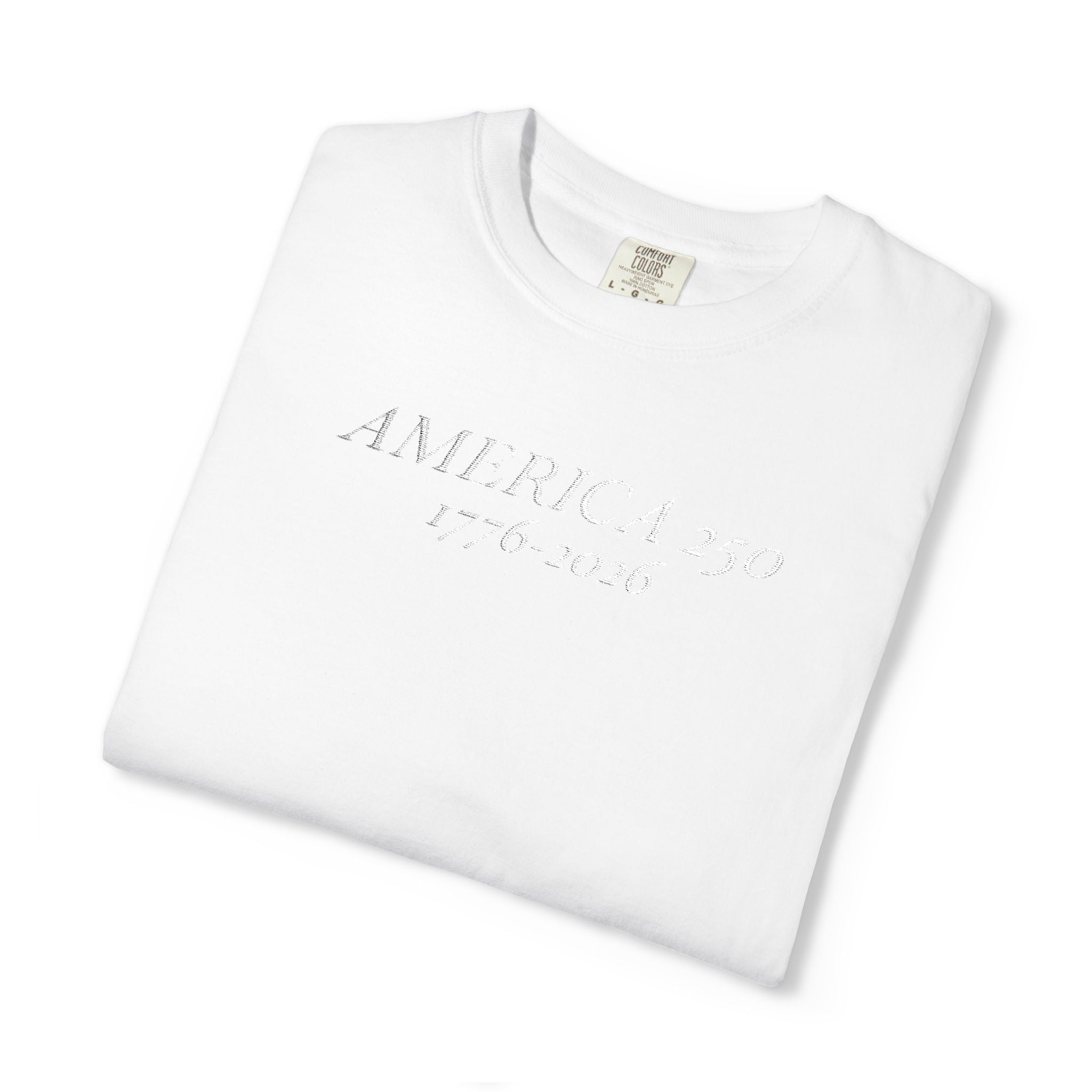 Folded White Comfort Colors t-shirt with 'AMERICA 250 1776-2026' embroidered in white thread