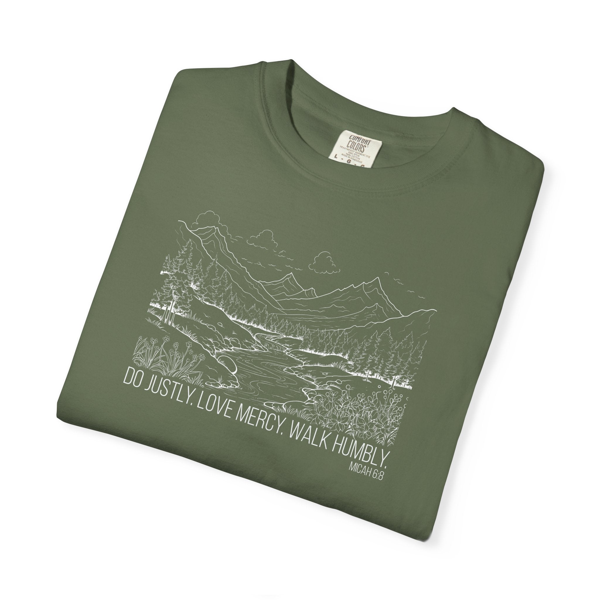 Folded sage Comfort Colors t-shirt with mountain river design and Bible verse from Micah 6:8