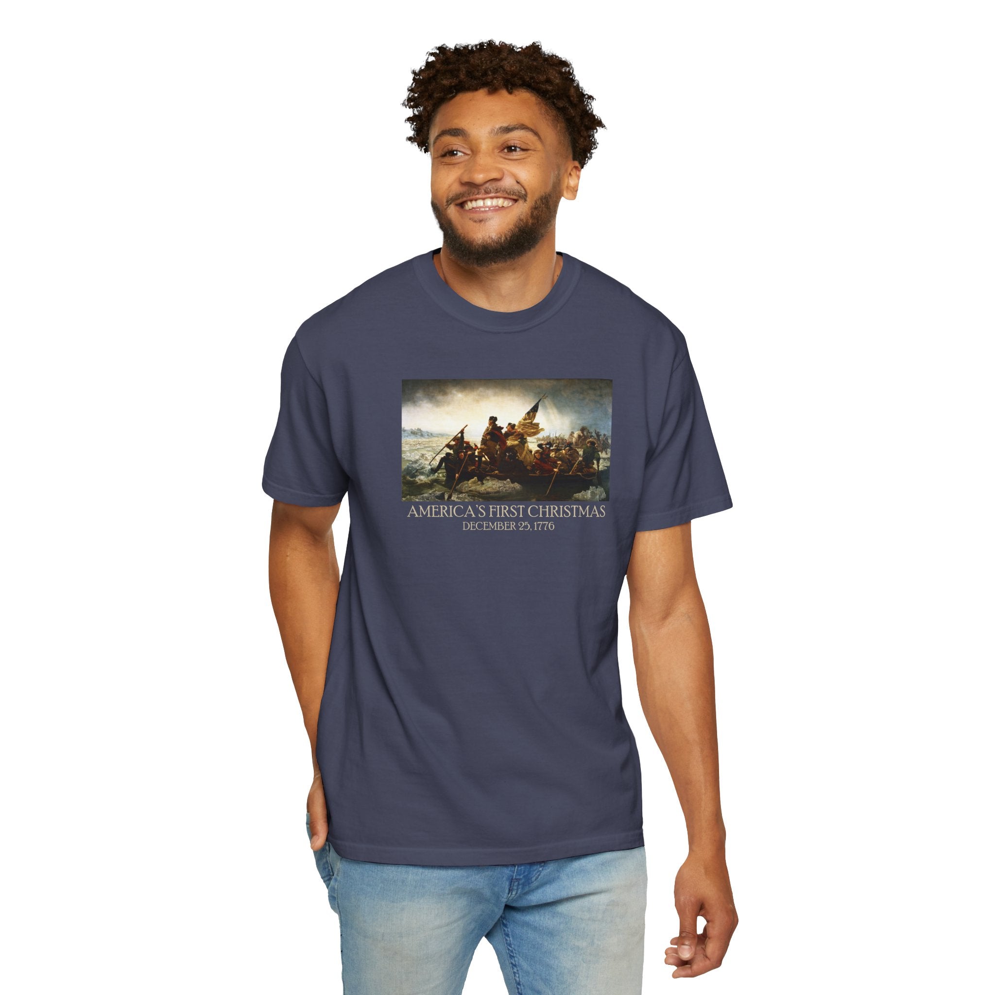 Smiling Man wearing a Denim Comfort Colors t-shirt with print of Emanuel Leutze’s 'Washington Crossing the Delaware' with 'America's First Christmas December 25, 1776' printed below 