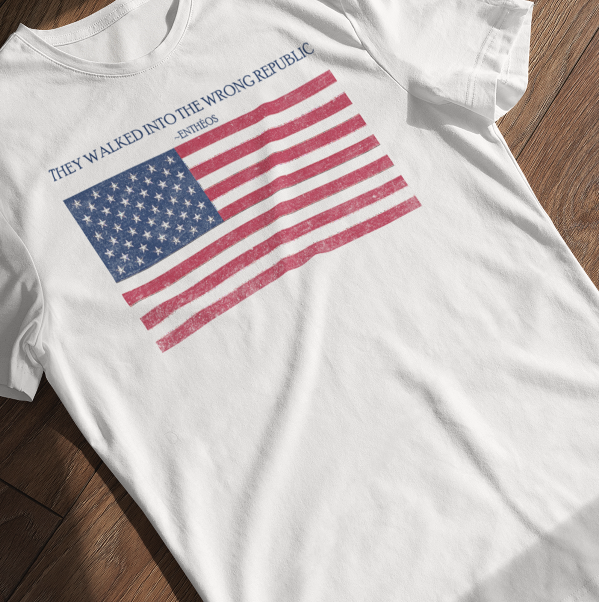 white t-shirt with distressed American flag graphic and text on a wooden surface