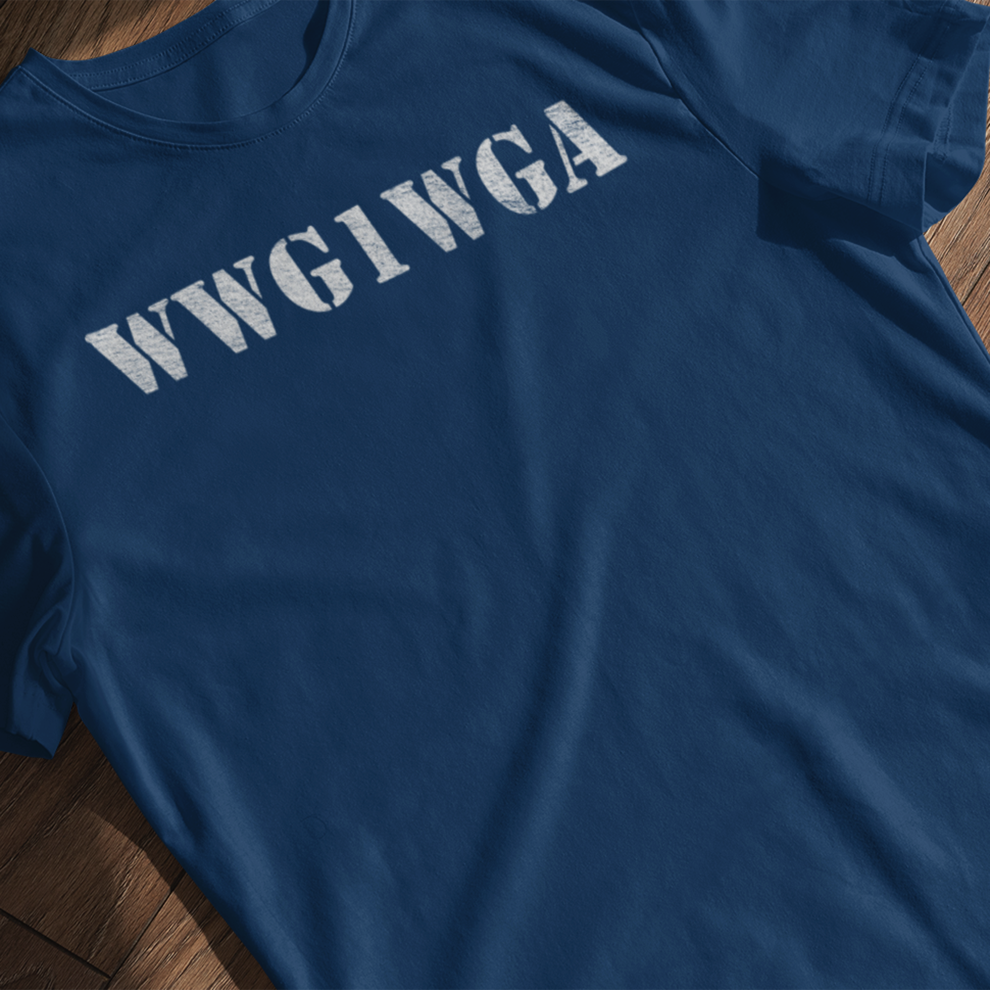 WWG1WGA distressed stencil patriotic t-shirt in blue laying flat on a wooden background