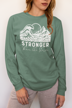Woman wearing Stronger Than The Storm long sleeve faith t-shirt in light green