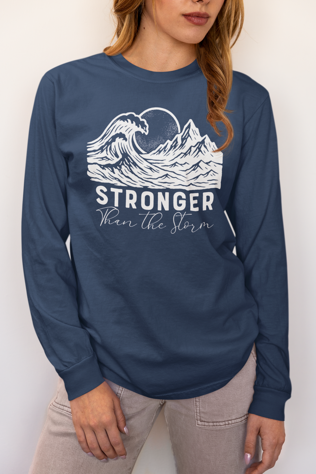 Woman wearing Stronger Than The Storm long sleeve faith t-shirt in Midnight