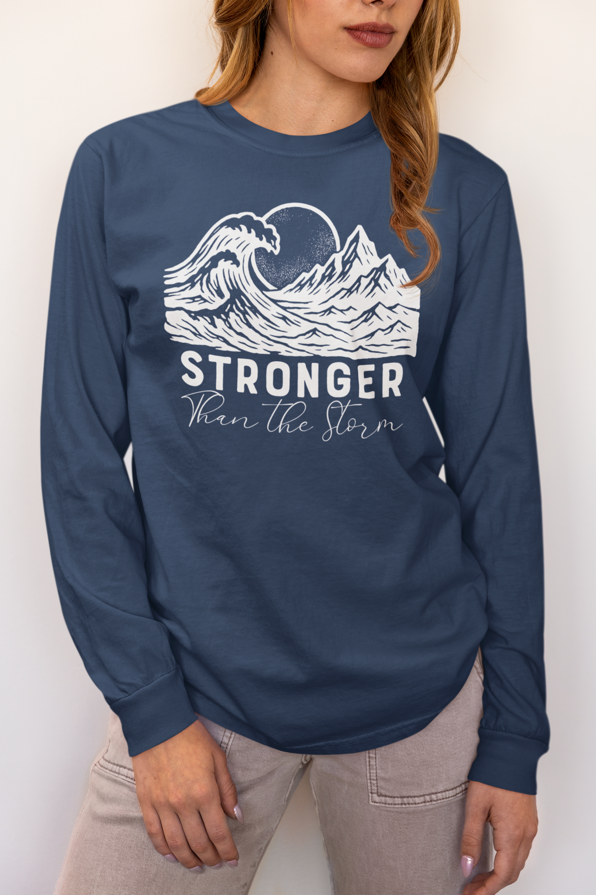 Woman wearing Stronger Than The Storm long sleeve faith t-shirt in Midnight