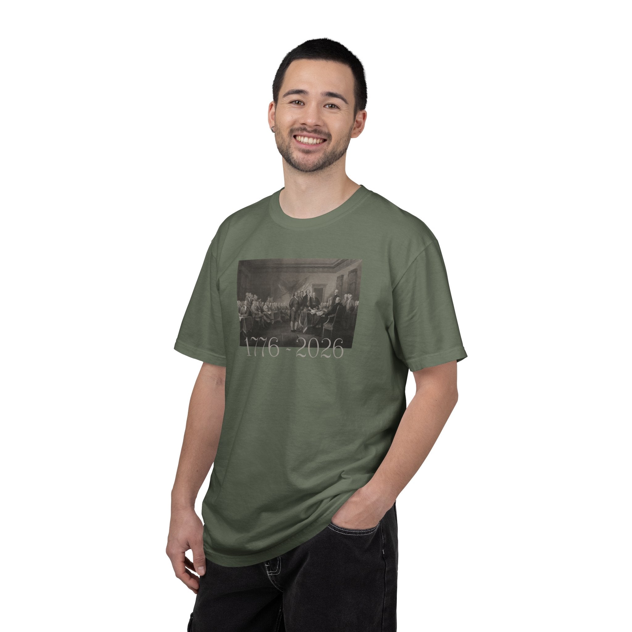 Man wearing a Moss Comfort Colors t-shirt with a printed design of Trumbull's  'Declaration of Independence' painting with '1776-2026' in overlapping revolutionary era text