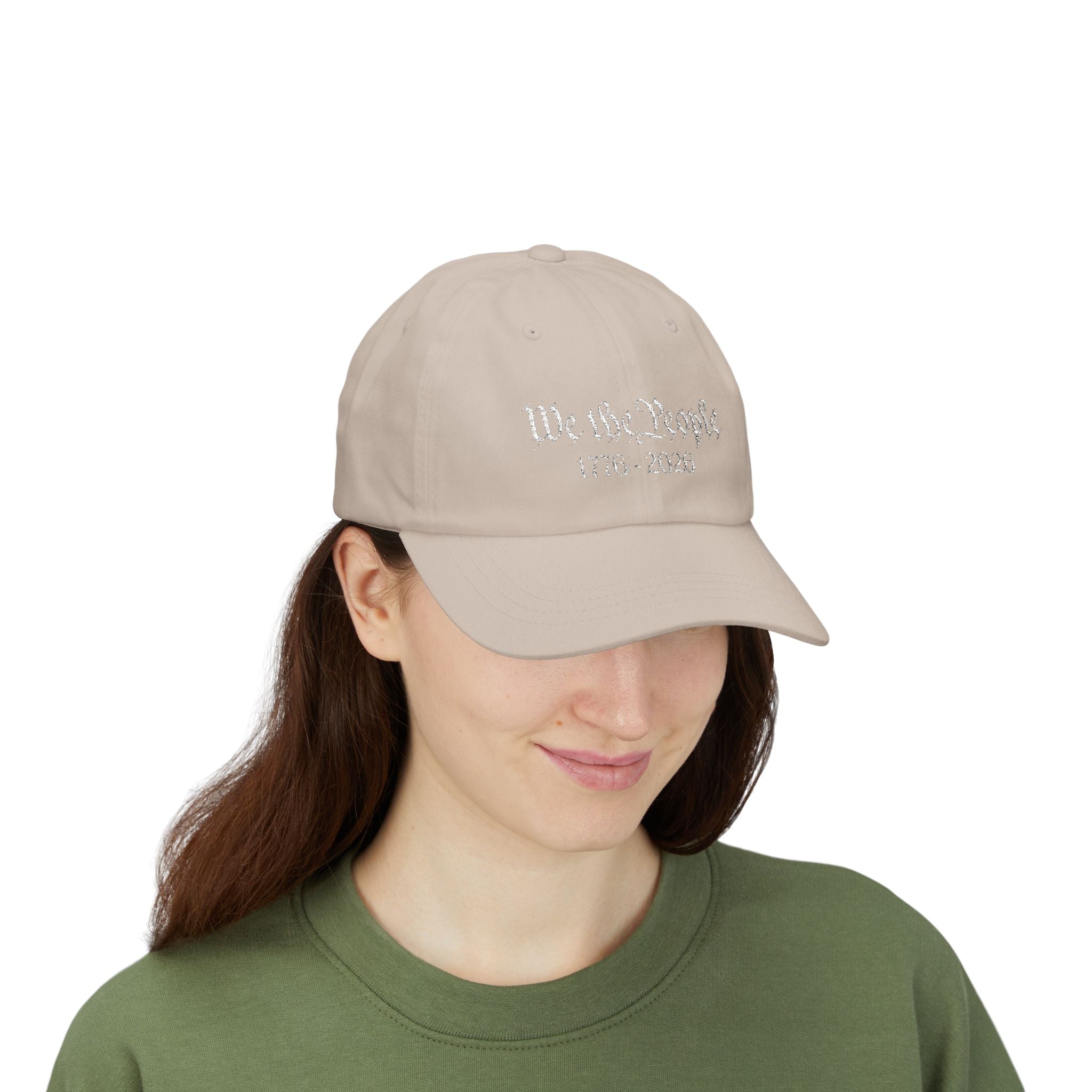 Woman wearing a beige cap with embroidered "We the People 1776-2026" 