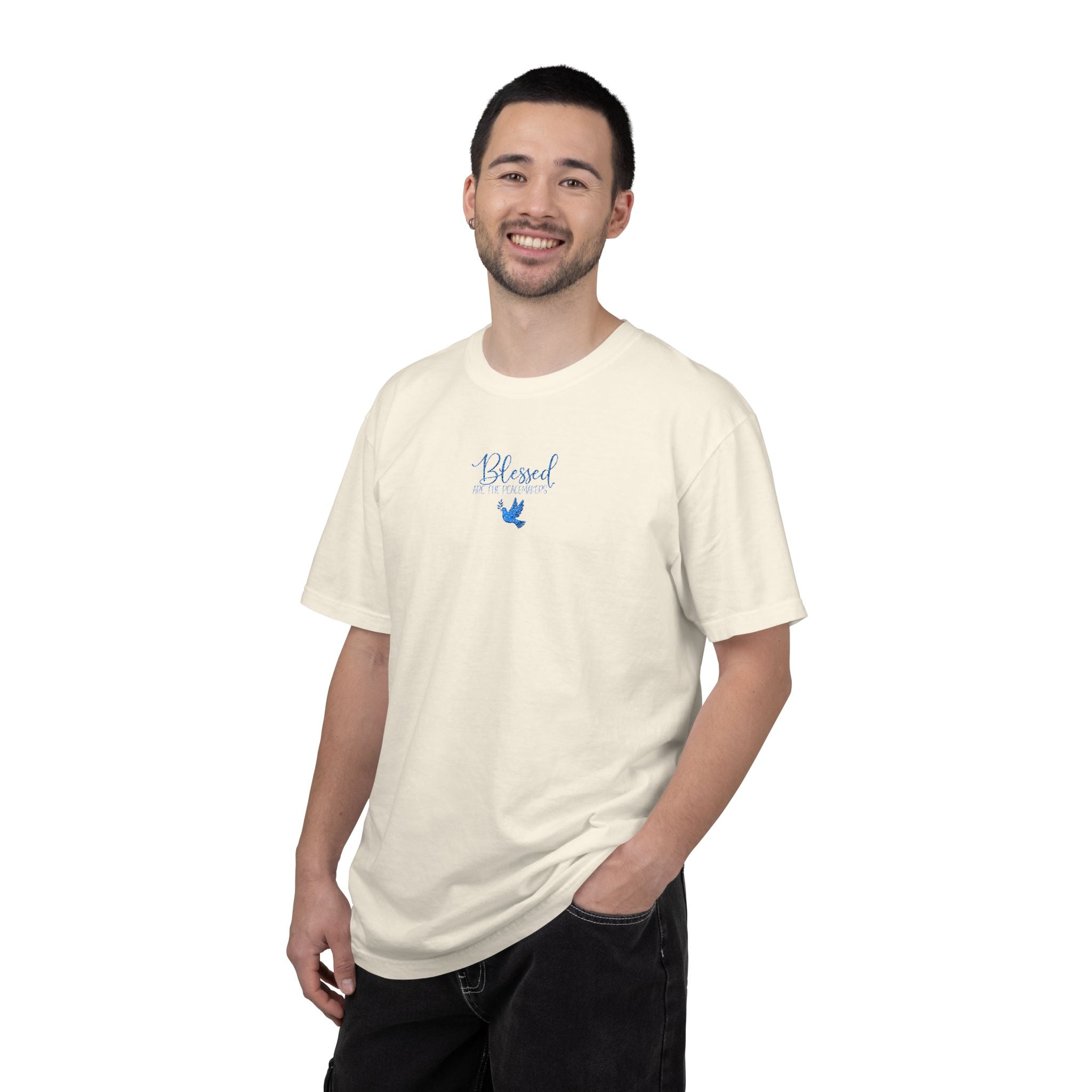 Smiling man wearing an Ivory Comfort Colors t-shirt with "Blessed are the Peacemakers" + dove embroidered with cornflower blue thread