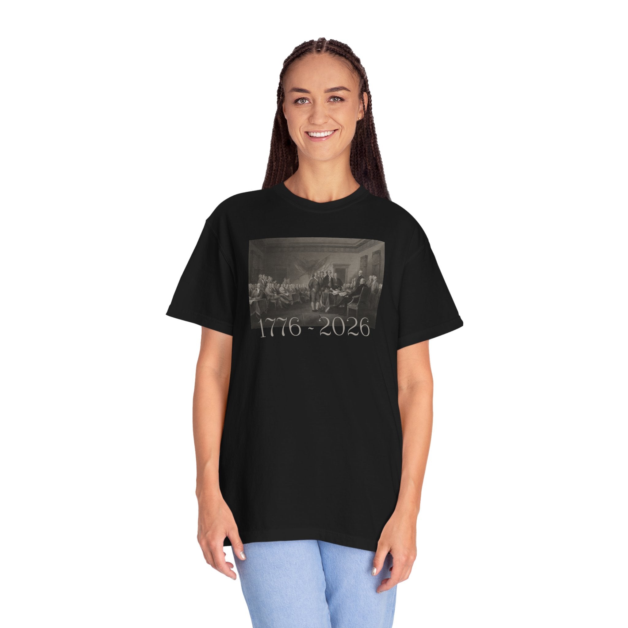 Woman wearing an oversized Black Comfort Colors t-shirt with a printed design of Trumbull's  'Declaration of Independence' painting with '1776-2026' in overlapping revolutionary era text