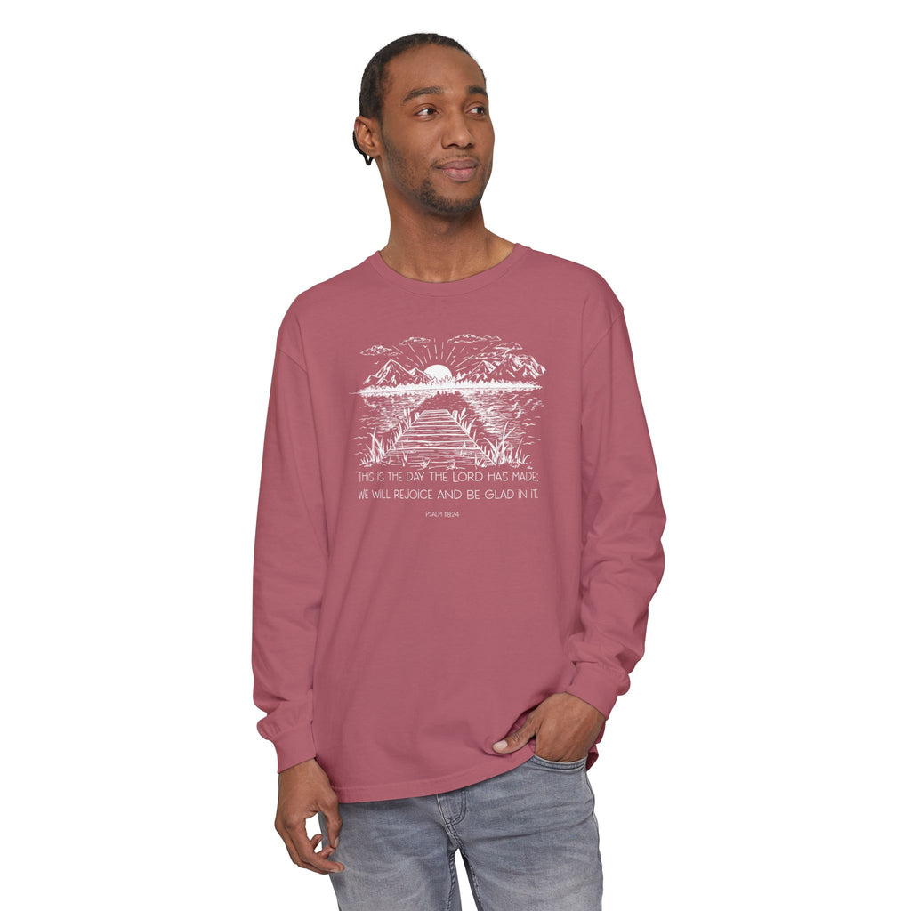 Man wearing a long-sleeve Crimson Comfort Colors t-shirt featuring Psalm 118:24 paired with a nature graphic 