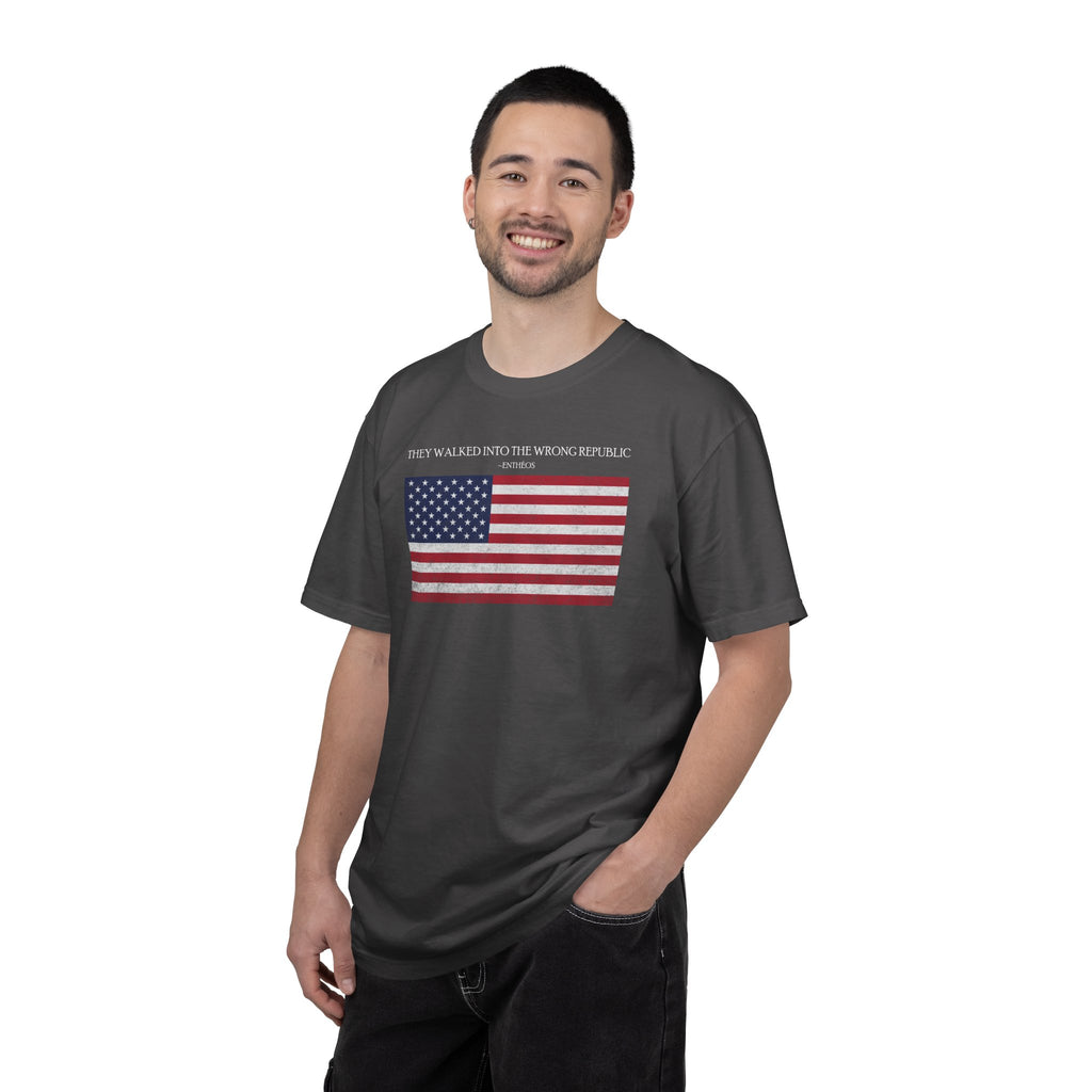 Smiling man wearing a Graphite Comfort Colors t-shirt with distressed American flag graphic and 'They Walked Into the Wrong Republic' quote from Entheos