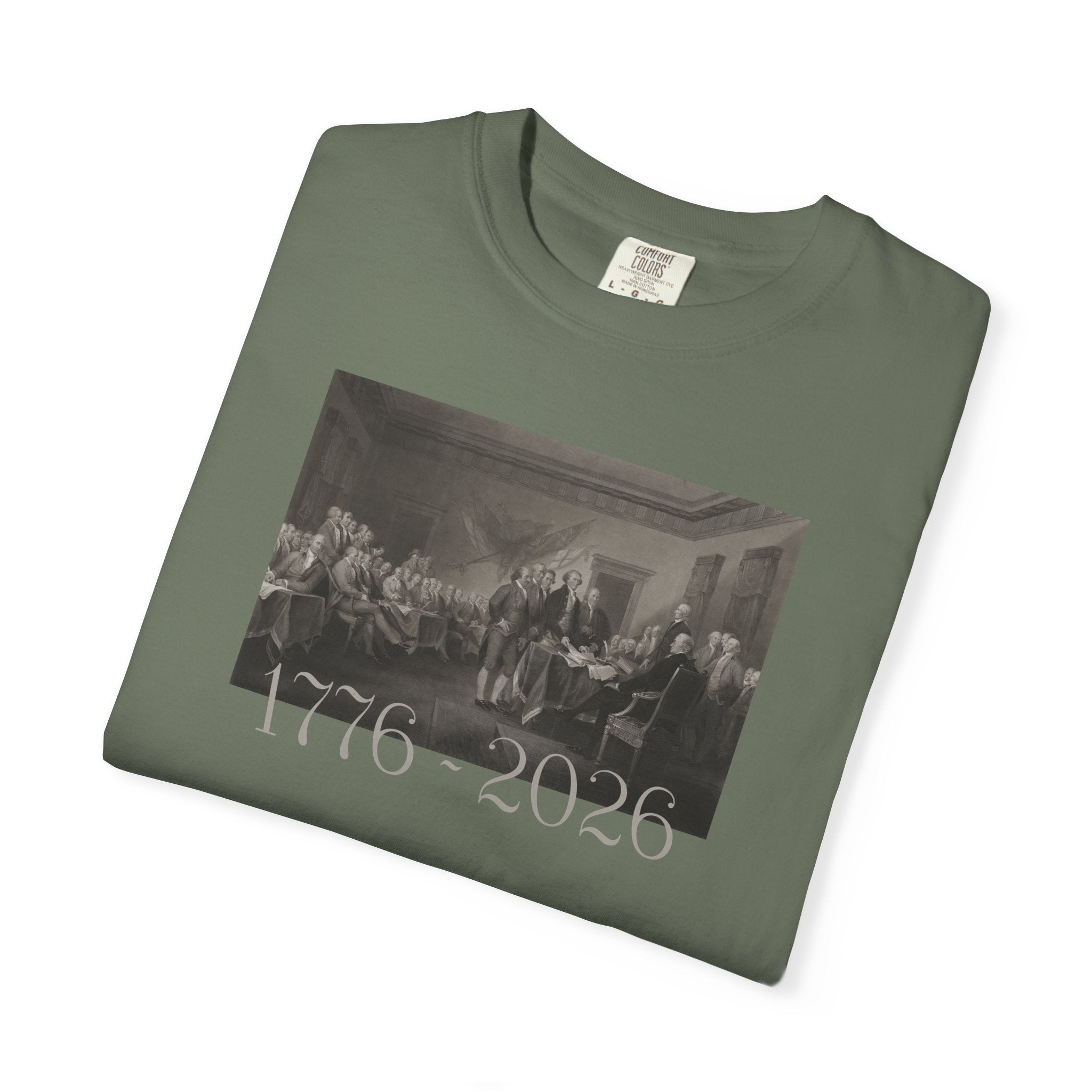 Folded Moss Comfort Colors t-shirt with a printed design of Trumbull's  'Declaration of Independence' painting with '1776-2026' in overlapping revolutionary era text
