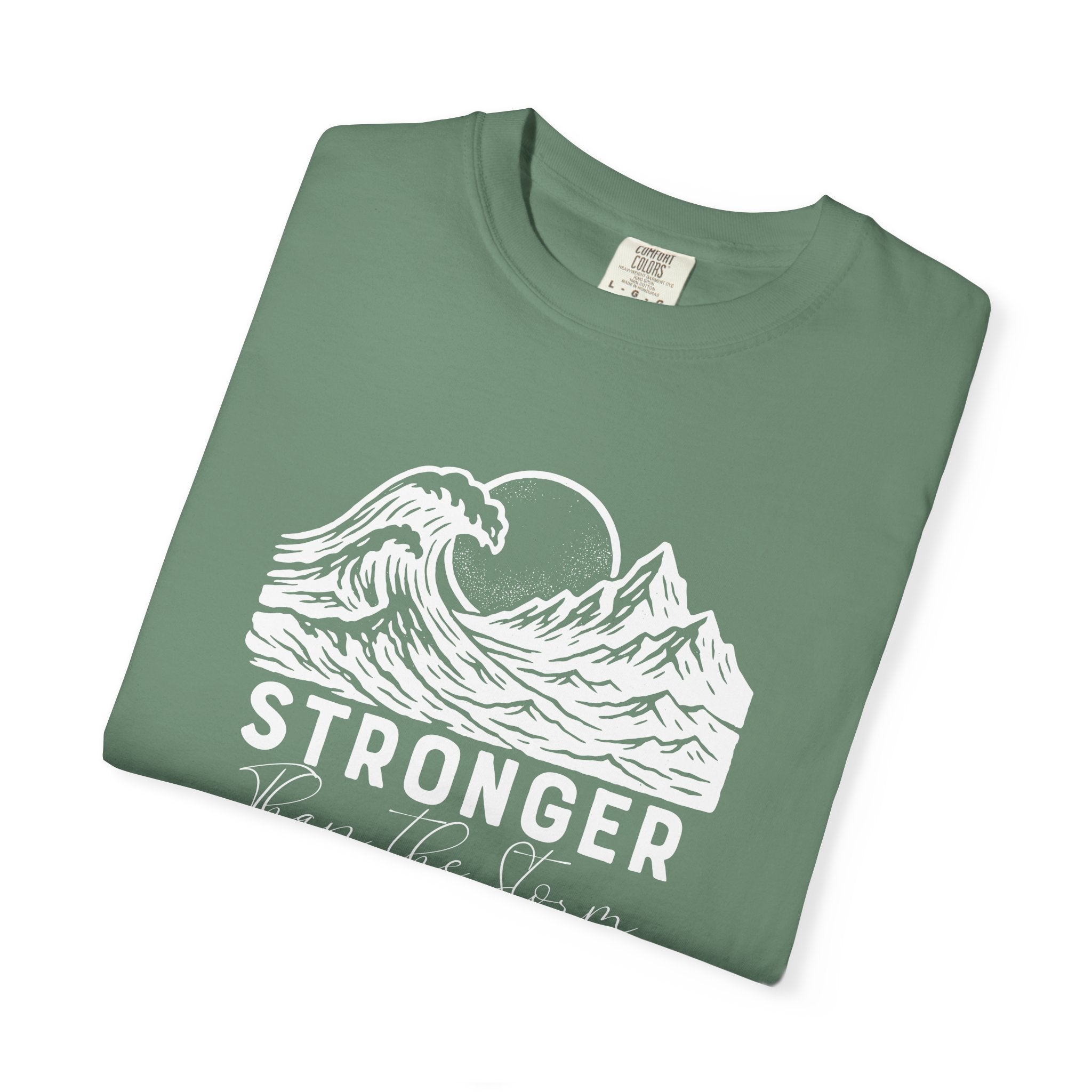 Folded Stronger Than The Storm Christian t-shirt in light green with a mountain wave sun design