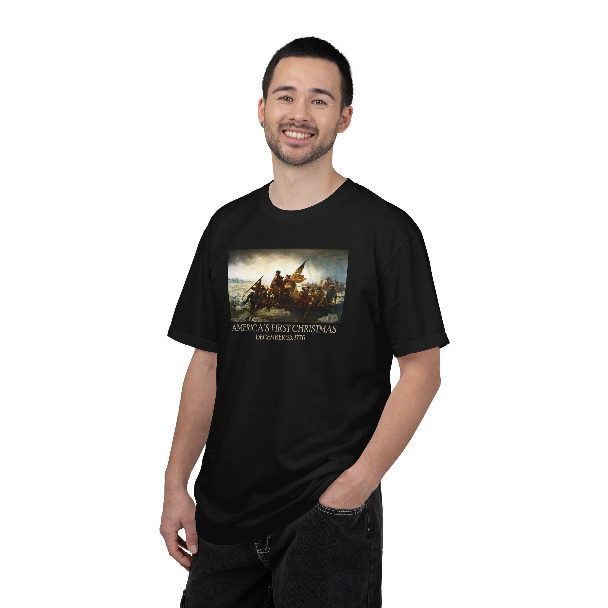 Smiling man wearing a Black Comfort Colors t-shirt with print of Emanuel Leutze’s 'Washington Crossing the Delaware' with 'America's First Christmas December 25, 1776' printed below 