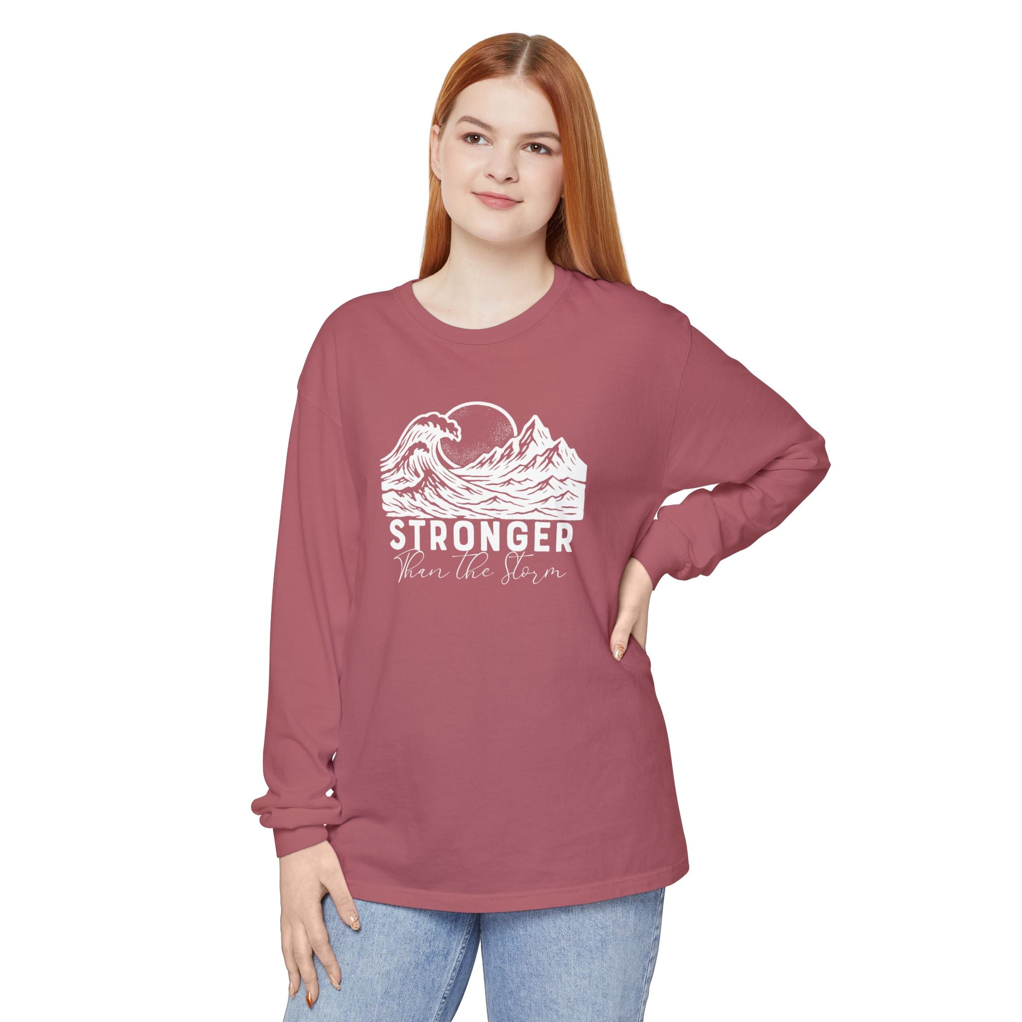 Person wearing Stronger Than The Storm faith long sleeve t-shirt in crimson
