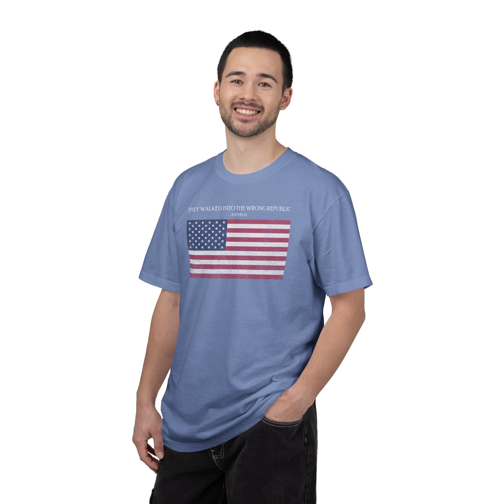 Smiling man wearing a Washed Denim Comfort Colors t-shirt with distressed American flag graphic and 'They Walked Into the Wrong Republic' quote from Entheos