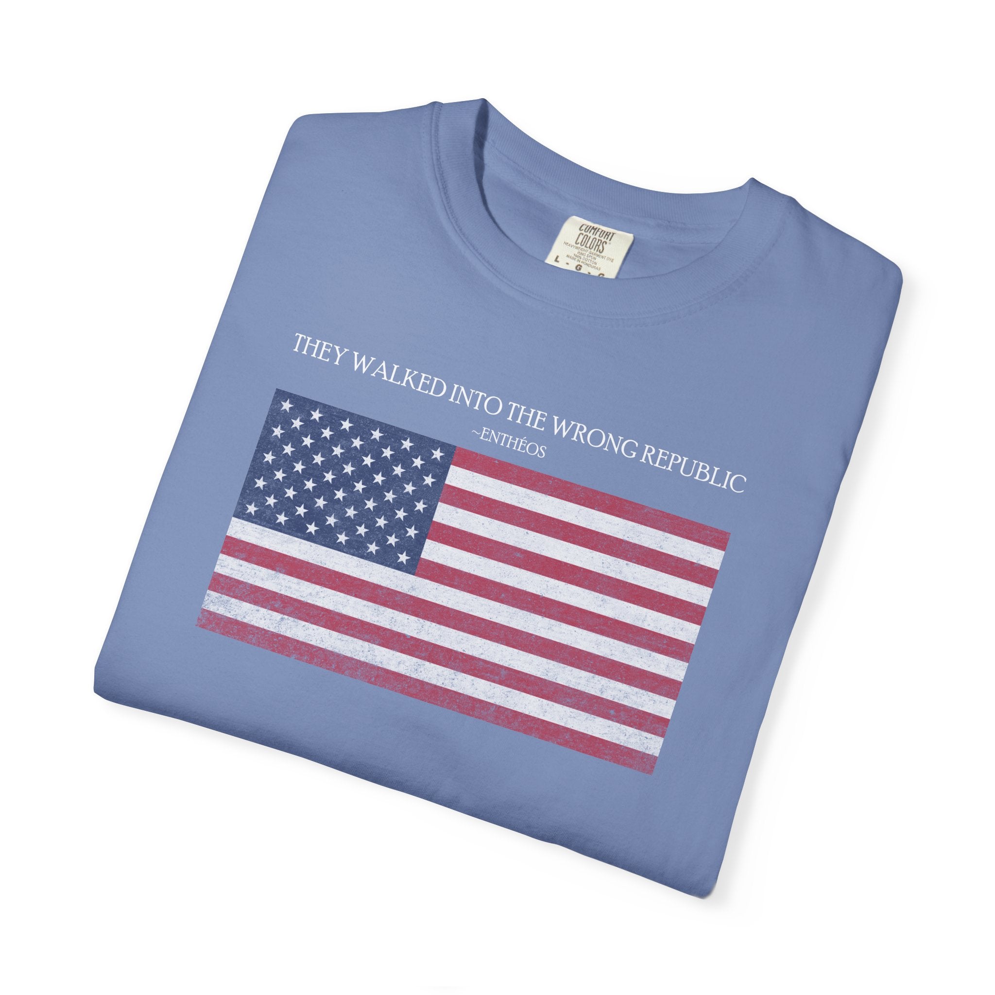 Folded Washed Denim Comfort Colors t-shirt with distressed American flag graphic and 'They Walked Into the Wrong Republic" quote from Entheos