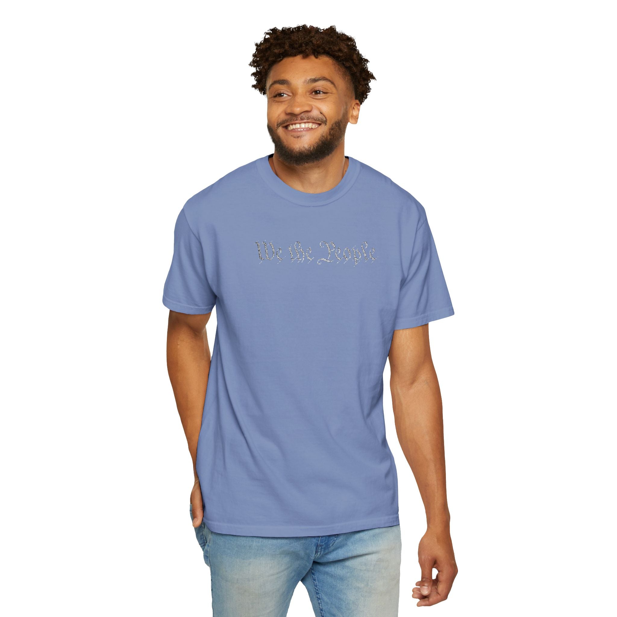 Smiling man wearing 'We the People' embroidered t-shirt in washed denim