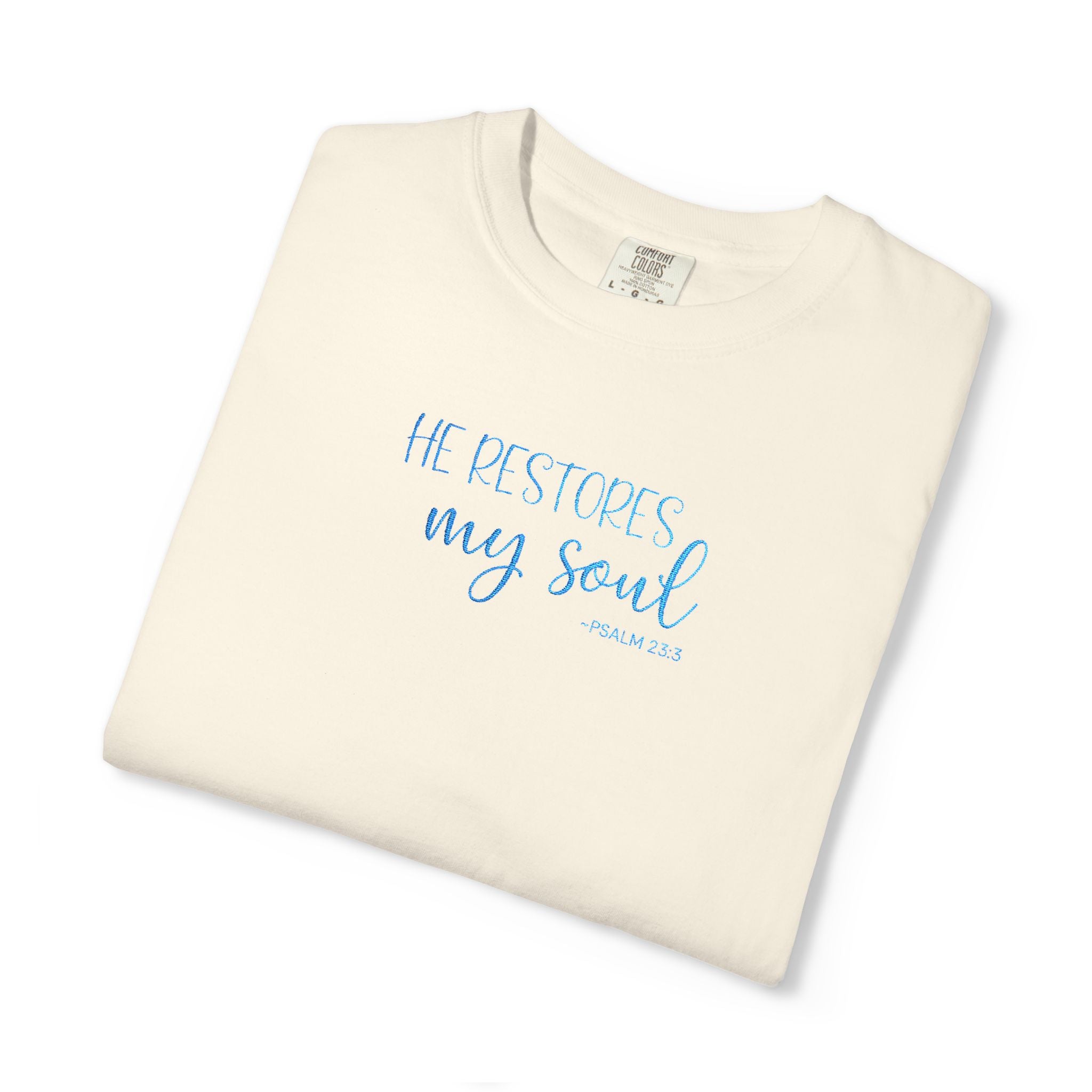 Ivory 'He Restores My Soul' t-shirt embroidered with cornflower blue thread, Psalm 23:3 design, folded