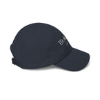 Side view of a navy blue cap with embroidered text 
