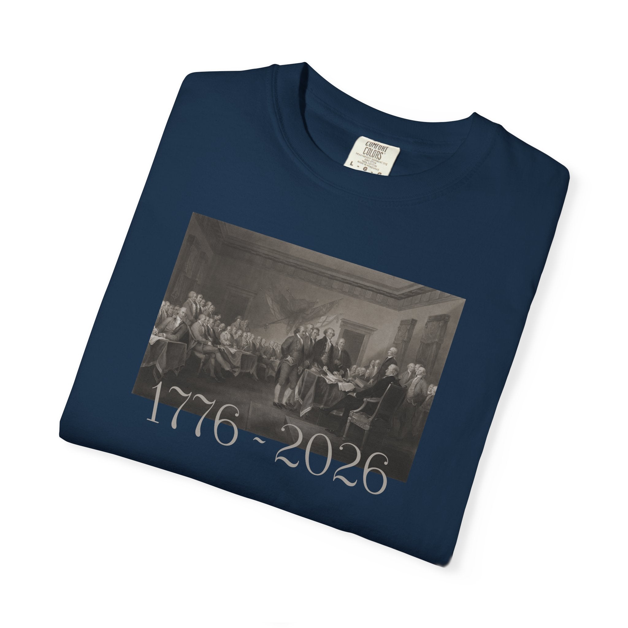 Folded True Navy Comfort Colors t-shirt with a printed design of Trumbull's  'Declaration of Independence' painting with '1776-2026' in overlapping revolutionary era text