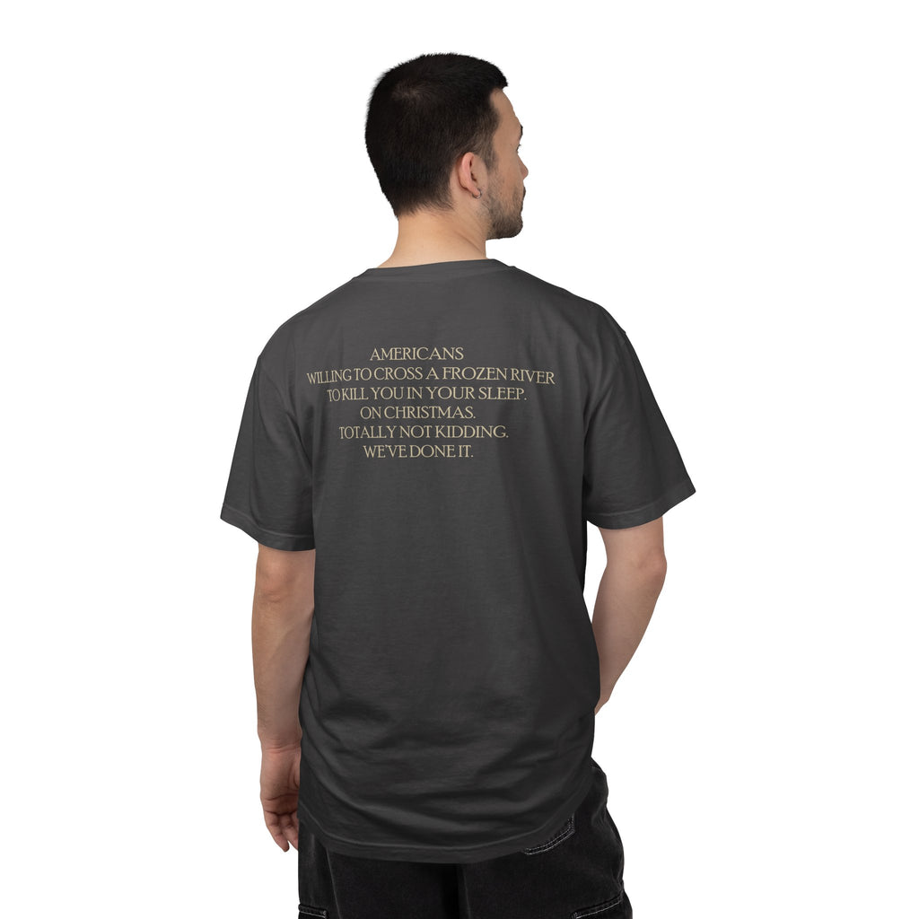 Back view of male model wearing America's First Christmas meme t-shirt with 'AMERICANS Willing to cross a frozen river to kill you in your sleep. On Christmas.' quote. Graphite