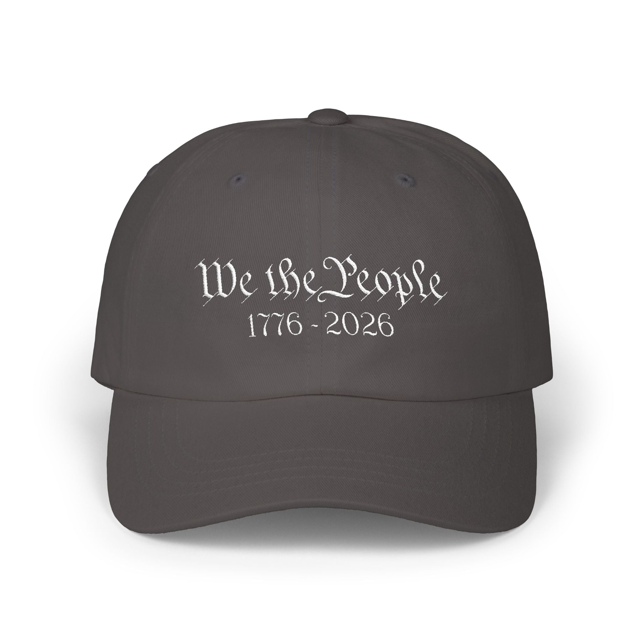 Dark grey cap with embroidered 'We the People 1776-2026' against a white background
