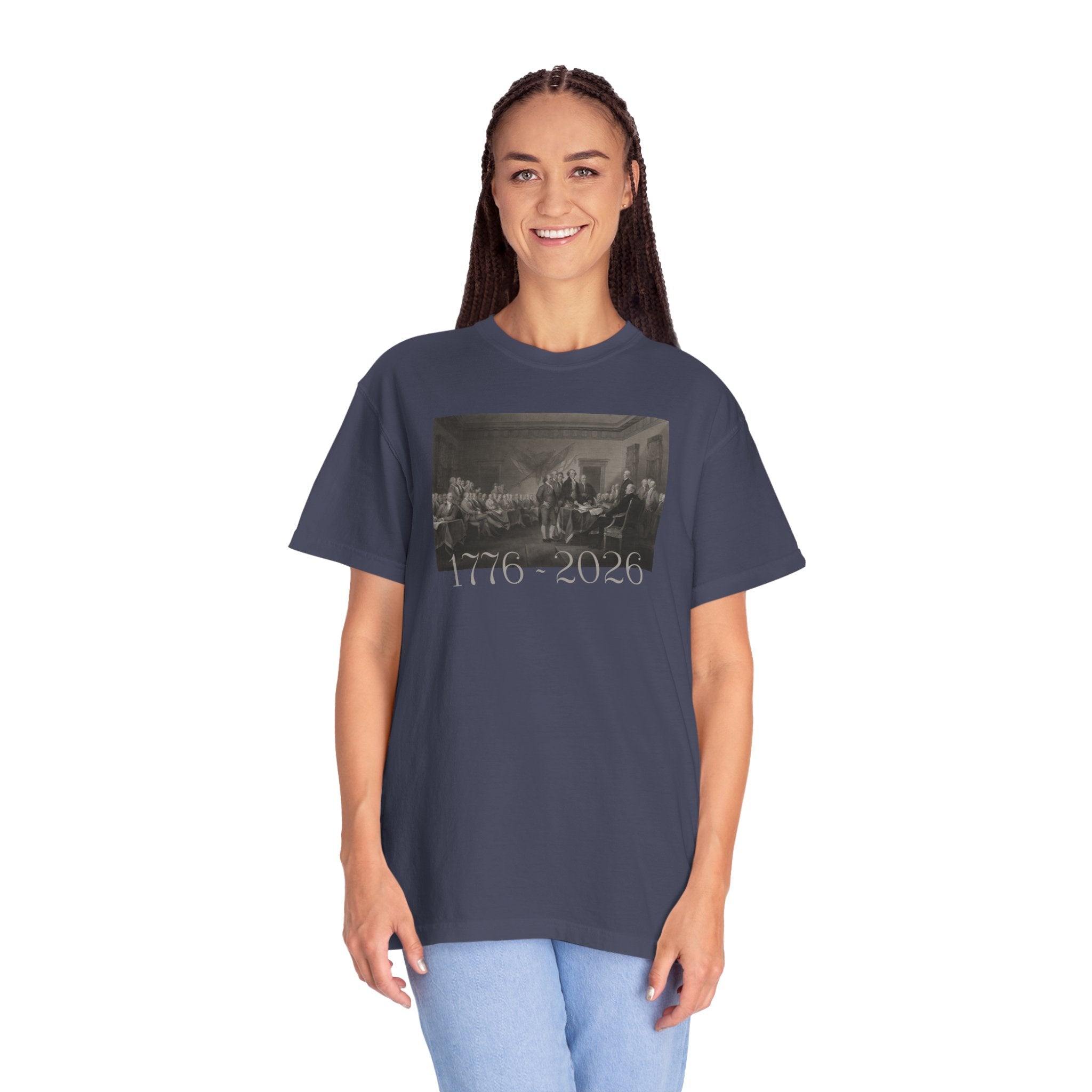 Woman wearing an oversized Denim Comfort Colors t-shirt with a printed design of Trumbull's  'Declaration of Independence' painting with '1776-2026' in overlapping revolutionary era text