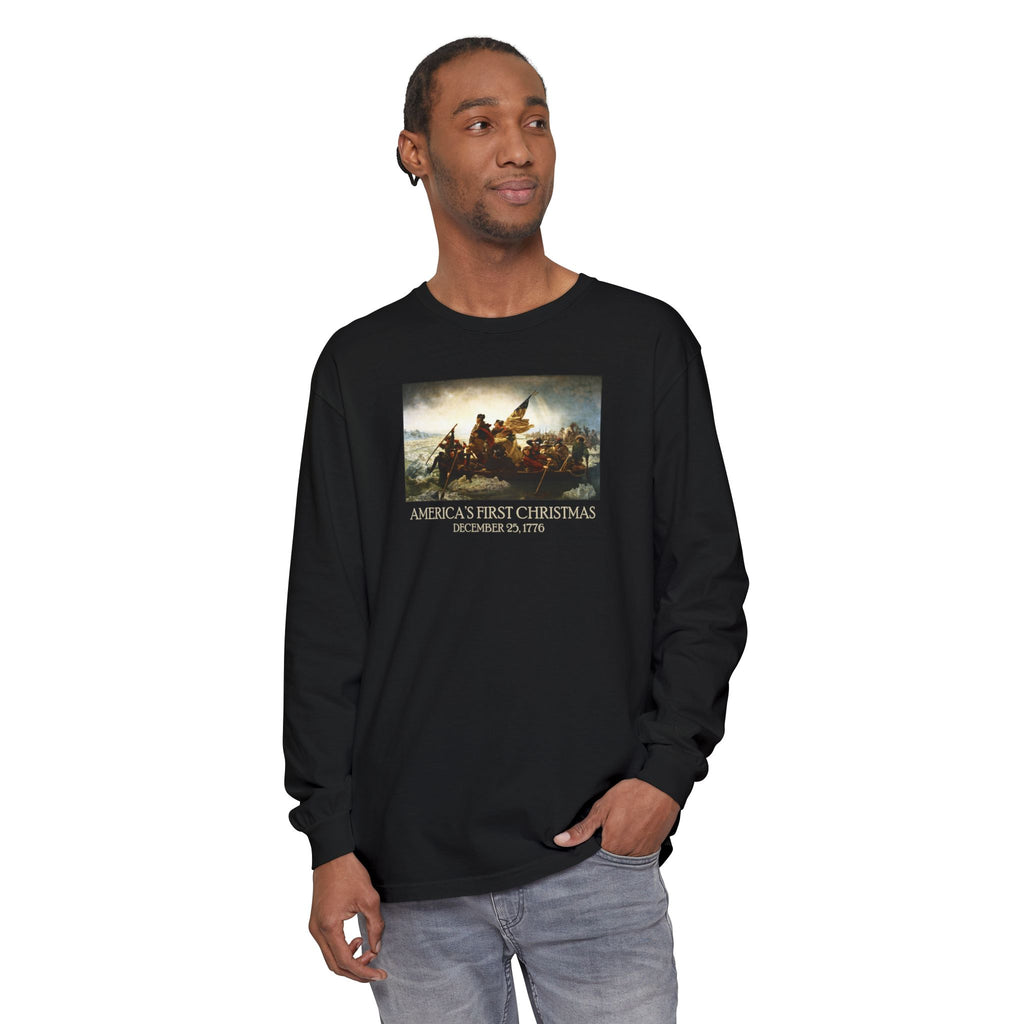 Man wearing a long-sleeve Black Comfort Colors t-shirt with Leutze's 'Washington Crossing the Delaware' with 'America's First Christmas December 25, 1776 printed below