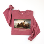 Folded long sleeve Crimson Comfort Colors t-shirt with Leutze's 'Washington Crossing the Delaware' and 'America's First Christmas December 25, 1776 printed beneath