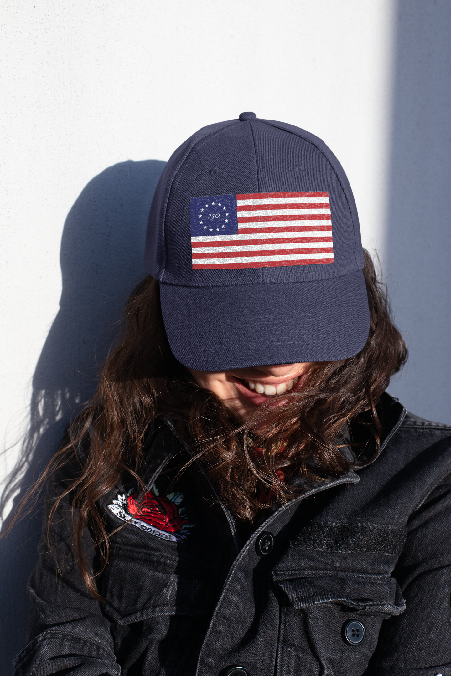 Model wearing a navy cap embroidered with Betsy Ross flag