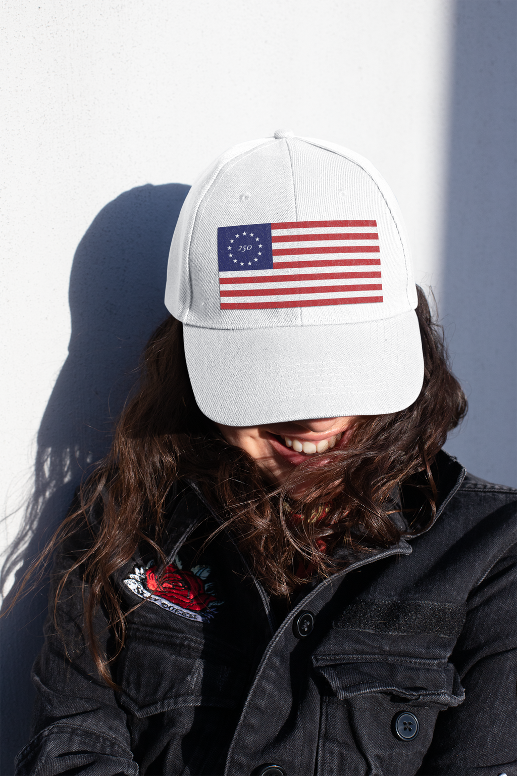 Model wearing a white cap embroidered with Betsy Ross flag