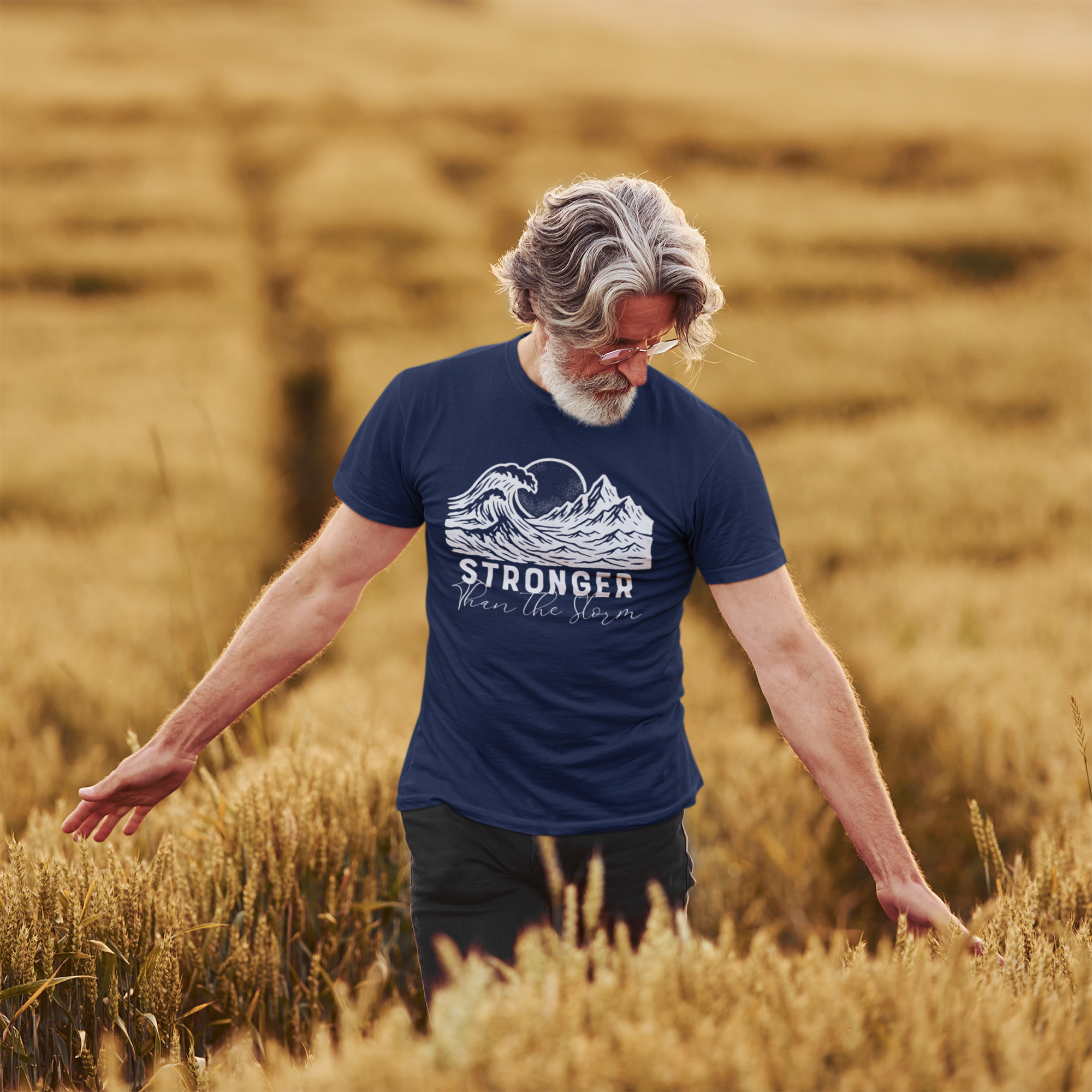 Man walking through a wheat field wearing a faith-inspired t-shirt